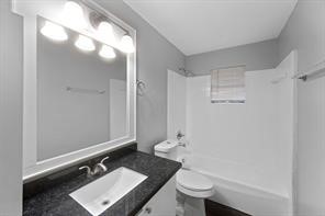1227 Fair Drive Angleton, TX 77515 - Photo 3 of 18 a bathroom with a sink a toilet a mirror and shower
