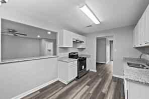 1227 Fair Drive Angleton, TX 77515 - Photo 5 of 18 a kitchen with granite countertop a sink stainless steel appliances and white cabinets