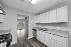 a kitchen with stainless steel appliances granite countertop a sink stove and cabinets