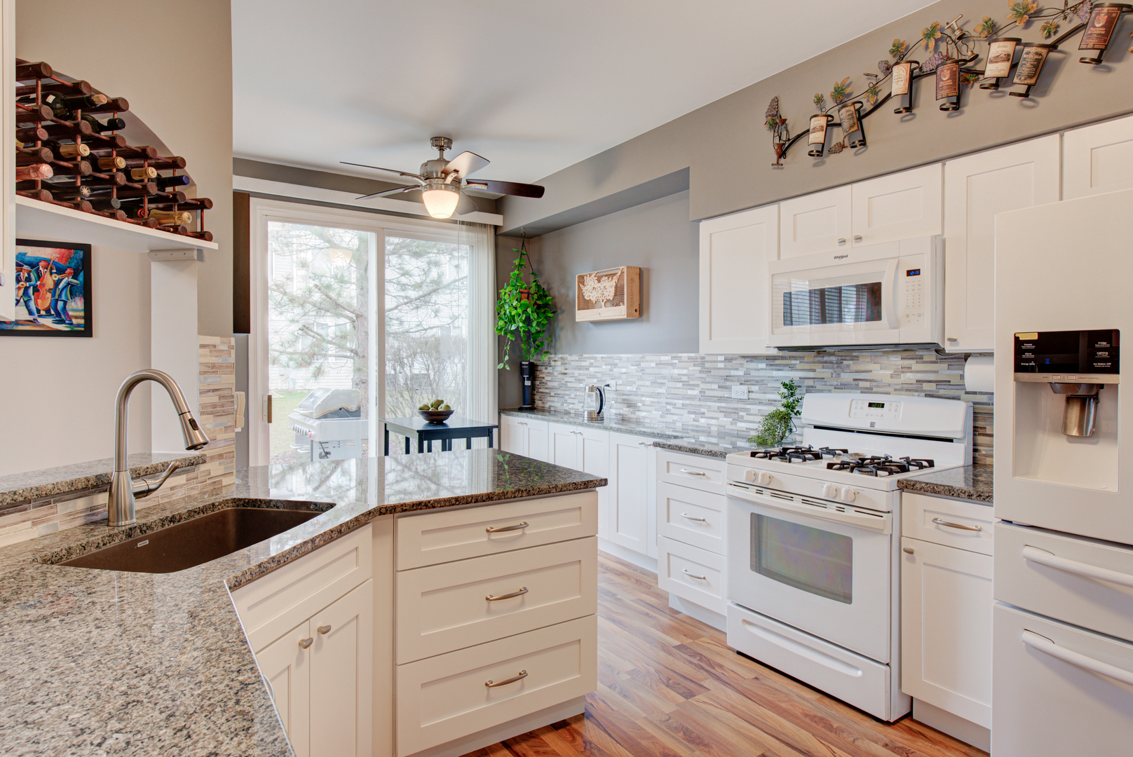 1201 Delta Drive Elgin, IL 60123 - Photo 10 of 42 a kitchen with granite countertop white cabinets white appliances a sink and a window