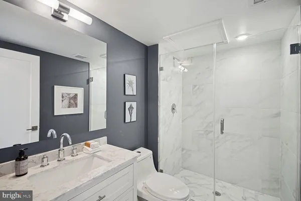 a bathroom with a sink toilet vanity and shower