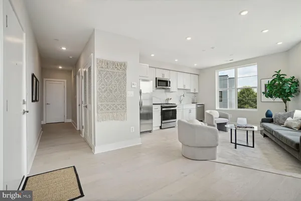 a living room with furniture a refrigerator and a stove