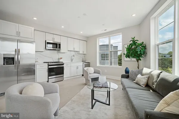 a living room with furniture a fireplace a flat screen tv and windows