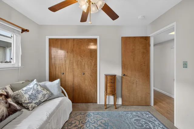 a view of a hallway with wooden floor and a bathroom