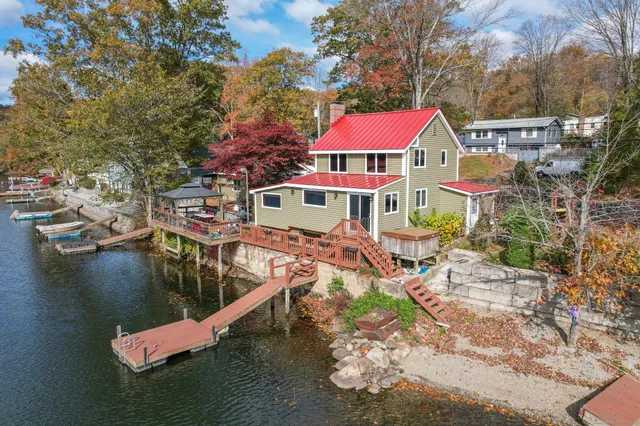 an aerial view of a house with swimming pool and lake view