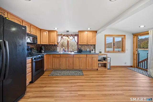 a kitchen with stainless steel appliances kitchen island granite countertop a refrigerator and a stove