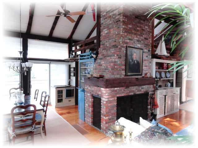 9 Chart Way Mashpee, MA 02649 - Photo 27 of 32 a living room with furniture a fireplace and a floor to ceiling window