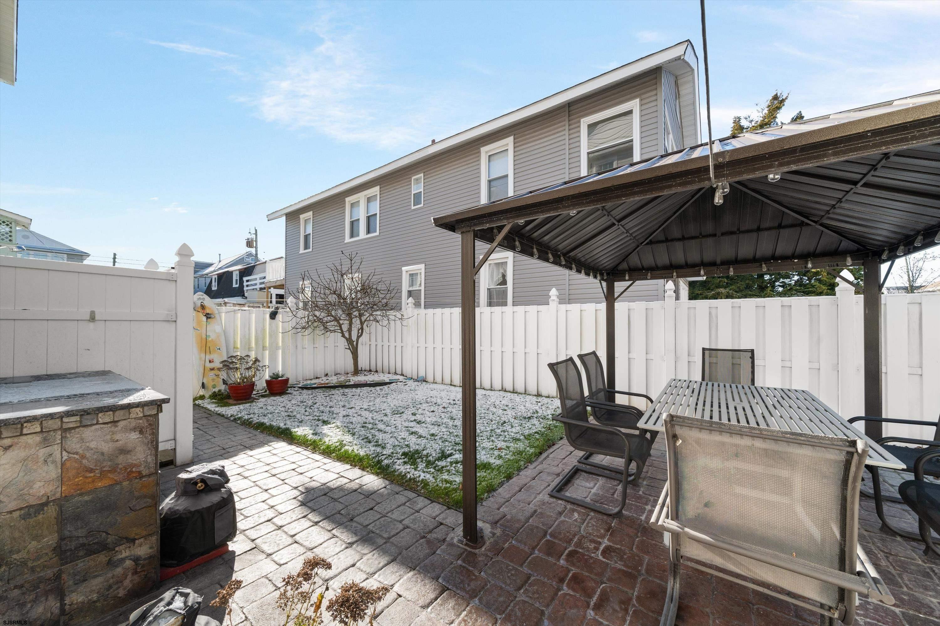 700 3rd Street Ocean City, NJ 08226 - Photo 18 of 38 a patio with a table and chairs under an umbrella