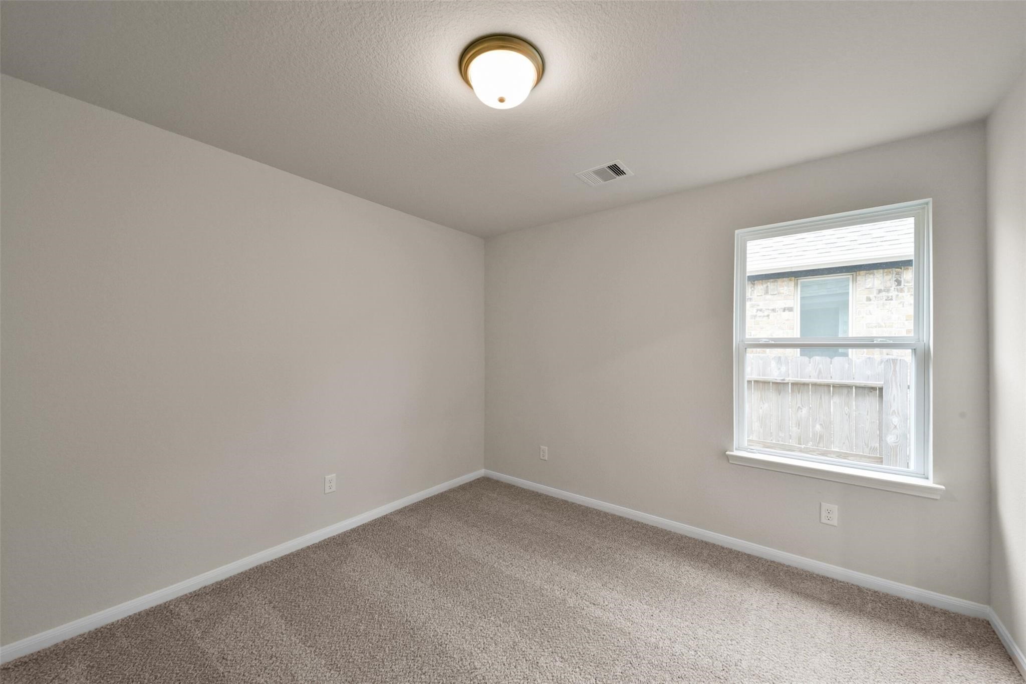 10522 Plumas Run Drive Rosharon, TX 77583 - Photo 14 of 29 Cozy, sunlit bedroom with plush carpeting and a large window—perfect for relaxation.