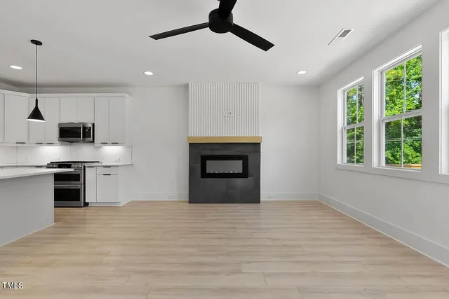 a kitchen with stainless steel appliances granite countertop a stove a refrigerator and a fireplace