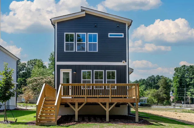 a view of a house with a deck and a yard
