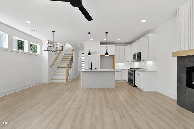 a kitchen with stainless steel appliances refrigerator wooden floor and window
