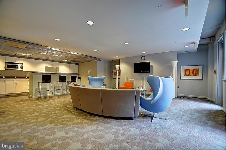 a living room with furniture a flat screen tv and kitchen view