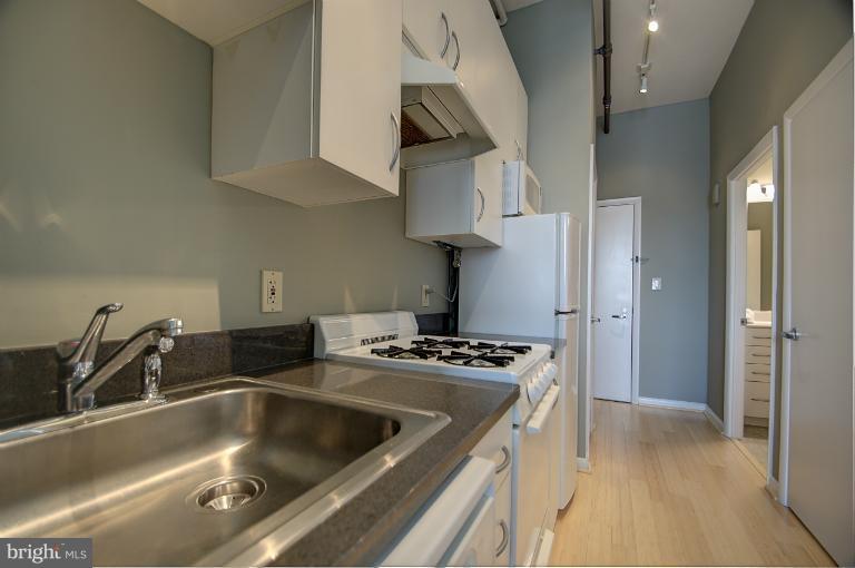 1300 N Street Northwest, Unit 812 Washington, DC 20005 - Photo 14 of 30 a kitchen that has stainless steel appliances a sink a stove and a refrigerator