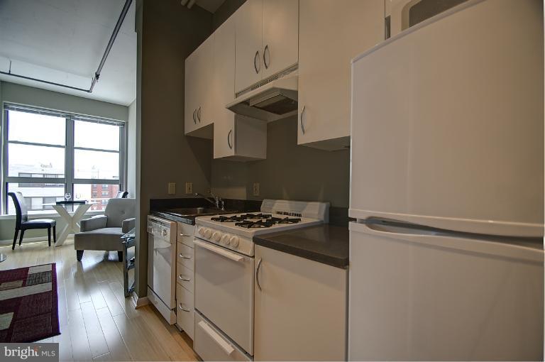 1300 N Street Northwest, Unit 812 Washington, DC 20005 - Photo 7 of 30 a kitchen with a stove and a wooden floor