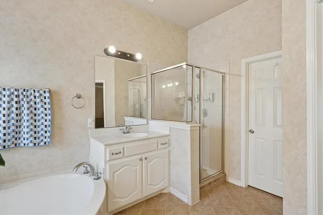 a bathroom with a double vanity sink a mirror a bathtub and shower