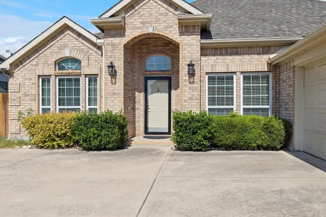 a view of a brick house with potted plants