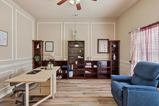 a living room with furniture kitchen view and a wooden floor