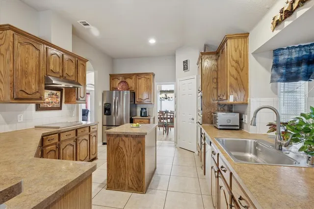 a kitchen with stainless steel appliances granite countertop a sink and a stove top oven with wooden floor