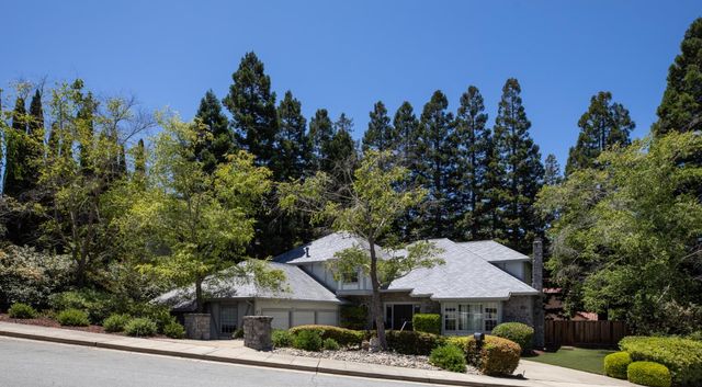 a front view of a house with a yard and trees