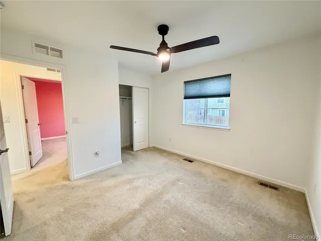 an empty room with closet and windows