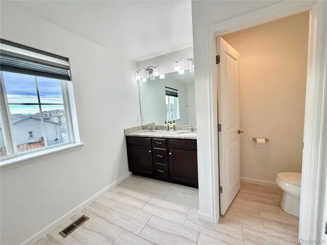 a bathroom with a double vanity sink toilet and shower