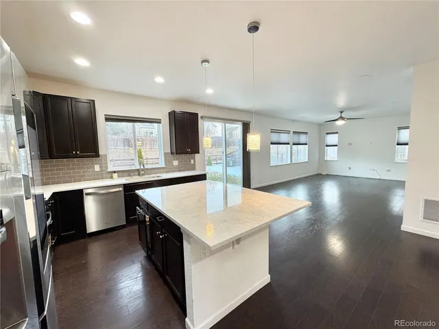 a kitchen with stainless steel appliances granite countertop a sink a stove top oven a counter space and cabinets