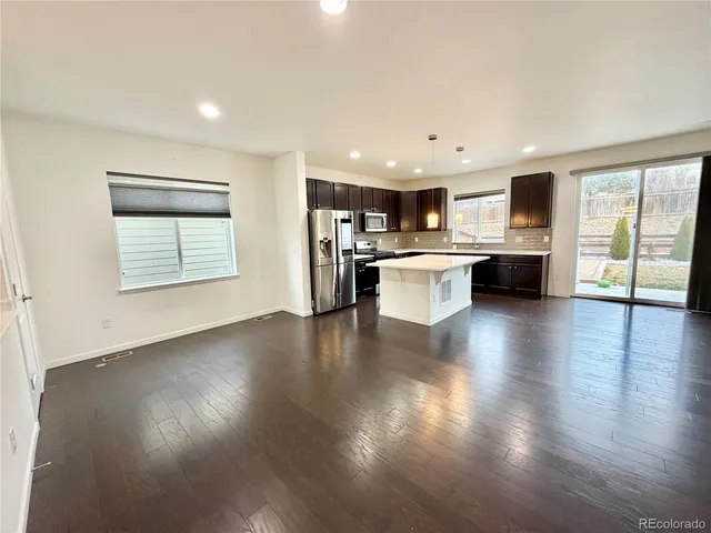 an open kitchen with white cabinets and wooden floor