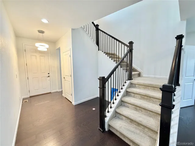 a view of staircase with white walls and railing
