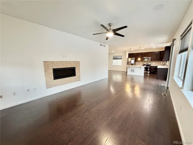 a view of a livingroom with wooden floor and a ceiling fan