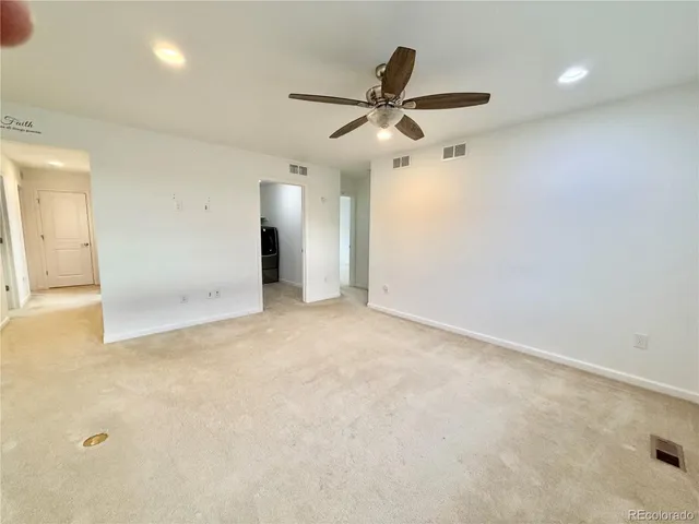 an empty room with a ceiling fan and window