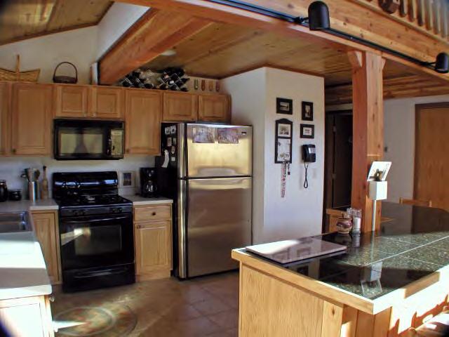 63 Algerie Road Becket, MA 01223 - Photo 2 of 5 a kitchen with stainless steel appliances granite countertop a refrigerator a stove and a sink with wooden floor