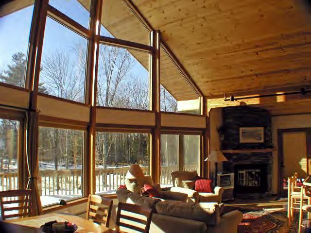 63 Algerie Road Becket, MA 01223 - Photo 3 of 5 a living room with fireplace furniture and a floor to ceiling window
