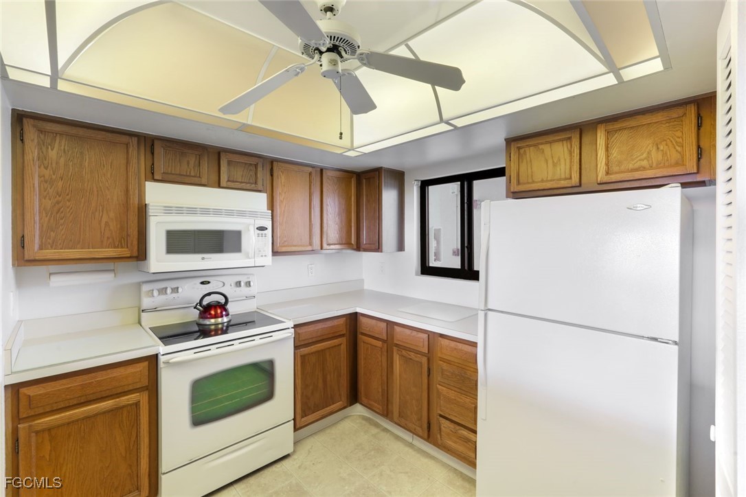 15011 Punta Rassa Road, Unit 505 Fort Myers, FL 33908 - Photo 13 of 40 a kitchen with stainless steel appliances granite countertop cabinets and a refrigerator