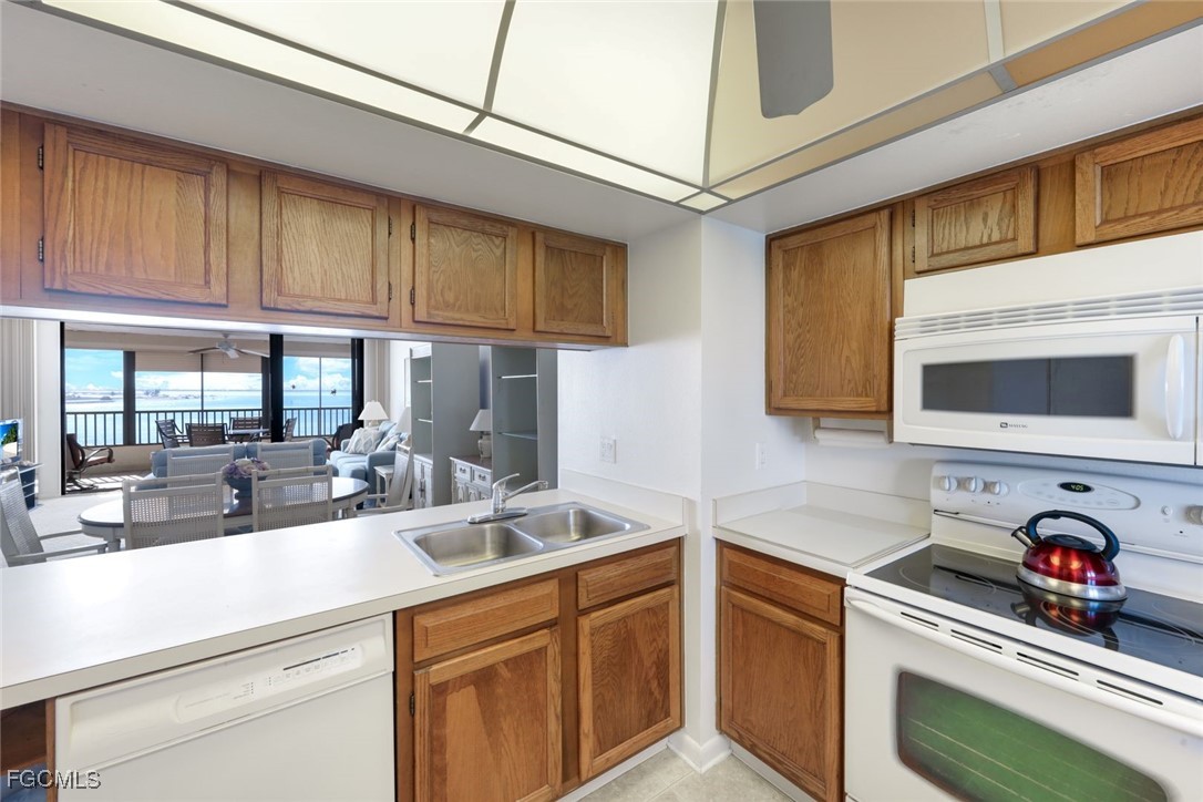 15011 Punta Rassa Road, Unit 505 Fort Myers, FL 33908 - Photo 16 of 40 a kitchen with stainless steel appliances granite countertop a sink and cabinets