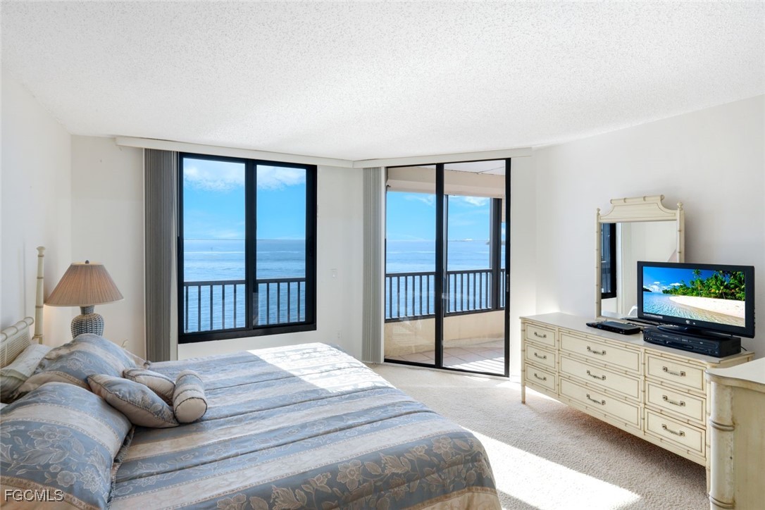 15011 Punta Rassa Road, Unit 505 Fort Myers, FL 33908 - Photo 2 of 40 a bedroom with a large bed and a tv