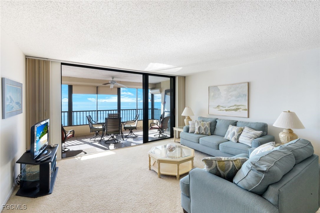 15011 Punta Rassa Road, Unit 505 Fort Myers, FL 33908 - Photo 10 of 40 a living room with furniture and a floor to ceiling window