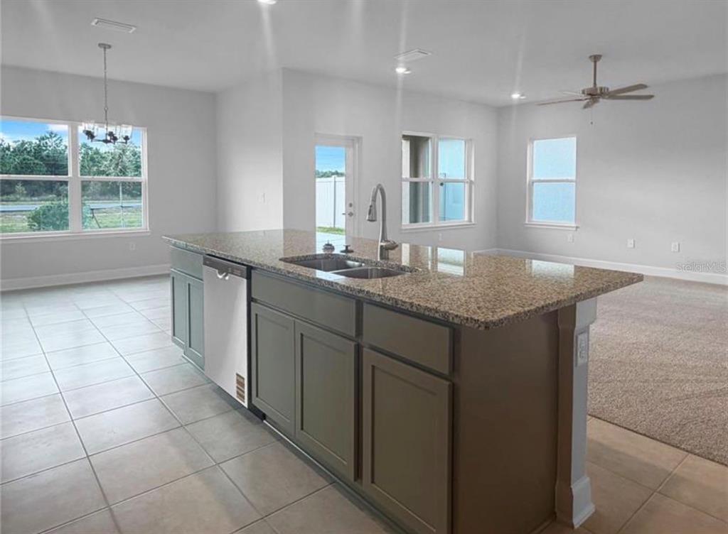 7643 Bent Tree Loop St. Cloud, FL 34773 - Photo 3 of 7 a kitchen with stainless steel appliances granite countertop a sink and a granite counter tops