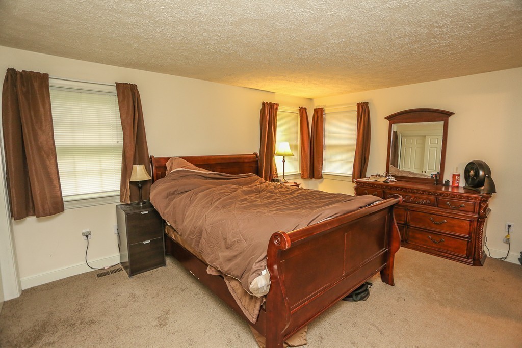 241 Winding Pond Road, Unit 241 Londonderry, NH 03053 - Photo 11 of 30 a bed sitting in a room next to a window