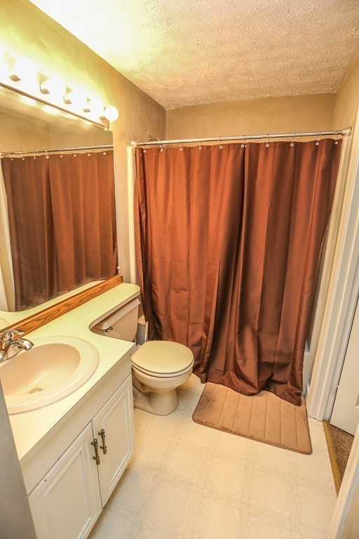 241 Winding Pond Road, Unit 241 Londonderry, NH 03053 - Photo 13 of 30 a bathroom with a toilet a sink and curtain