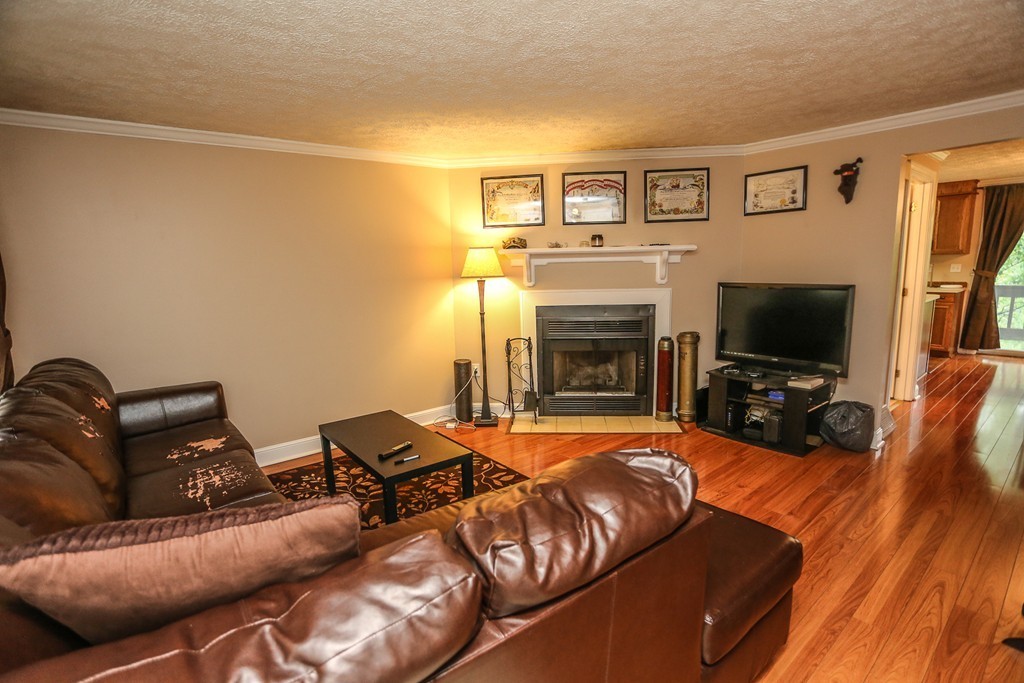 241 Winding Pond Road, Unit 241 Londonderry, NH 03053 - Photo 3 of 30 a living room with furniture and a flat screen tv