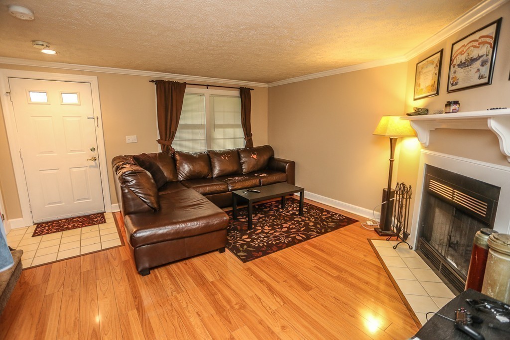 241 Winding Pond Road, Unit 241 Londonderry, NH 03053 - Photo 4 of 30 a living room with furniture and a fireplace