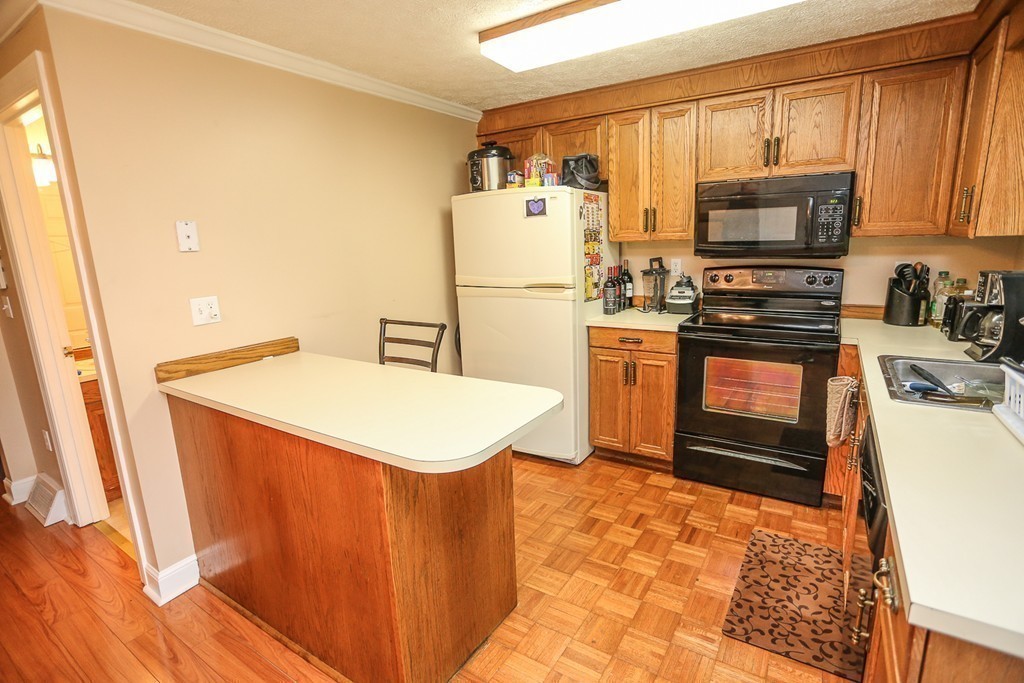 241 Winding Pond Road, Unit 241 Londonderry, NH 03053 - Photo 6 of 30 a kitchen with stainless steel appliances a stove a sink and a refrigerator