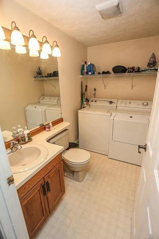 241 Winding Pond Road, Unit 241 Londonderry, NH 03053 - Photo 8 of 30 a bathroom with a sink a toilet and mirror