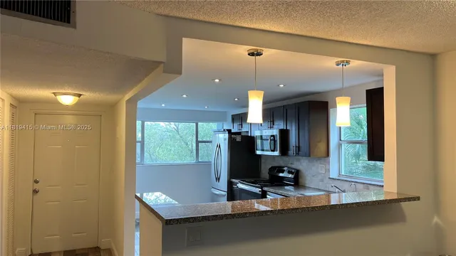 a kitchen with refrigerator and window