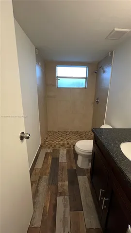 a bathroom with a granite countertop sink toilet and shower