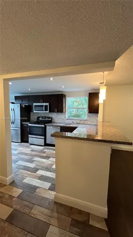 a kitchen with stainless steel appliances granite countertop a sink and a stove