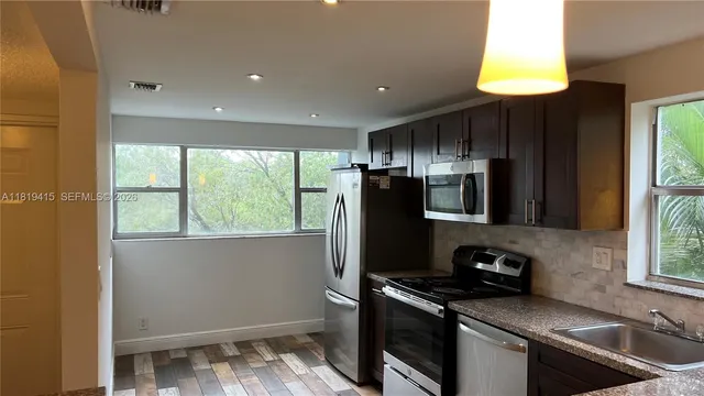 a kitchen that has a sink cabinets and a window