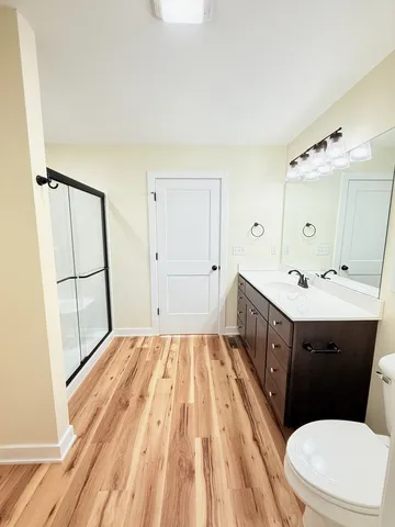 a bathroom with a double vanity sink toilet mirror and bathtub