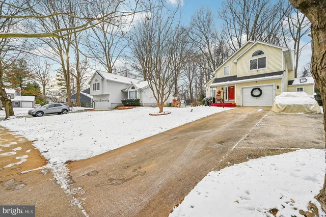 a front view of a house with a yard covered with snow
